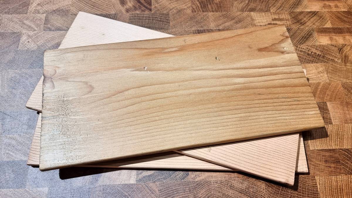 Three western red cedar planks stacked on a wood tab.