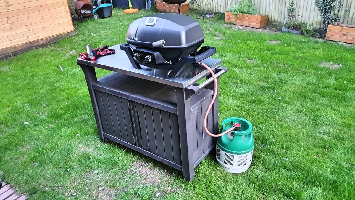 Napoleon Pro 285 gas grill on a stable, connected to a gas bottle, showing how short the hose .