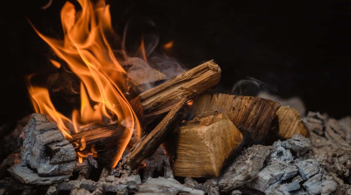 A pile of smoldering wood in a bbq smoker.