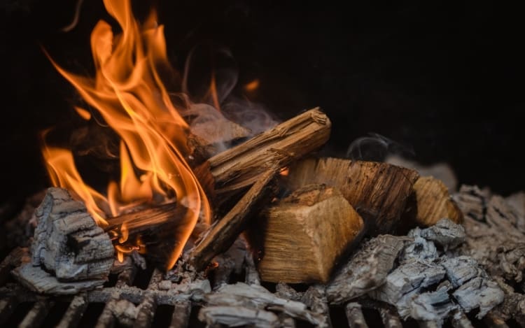 A pile of smoldering wood in a bbq smoker.