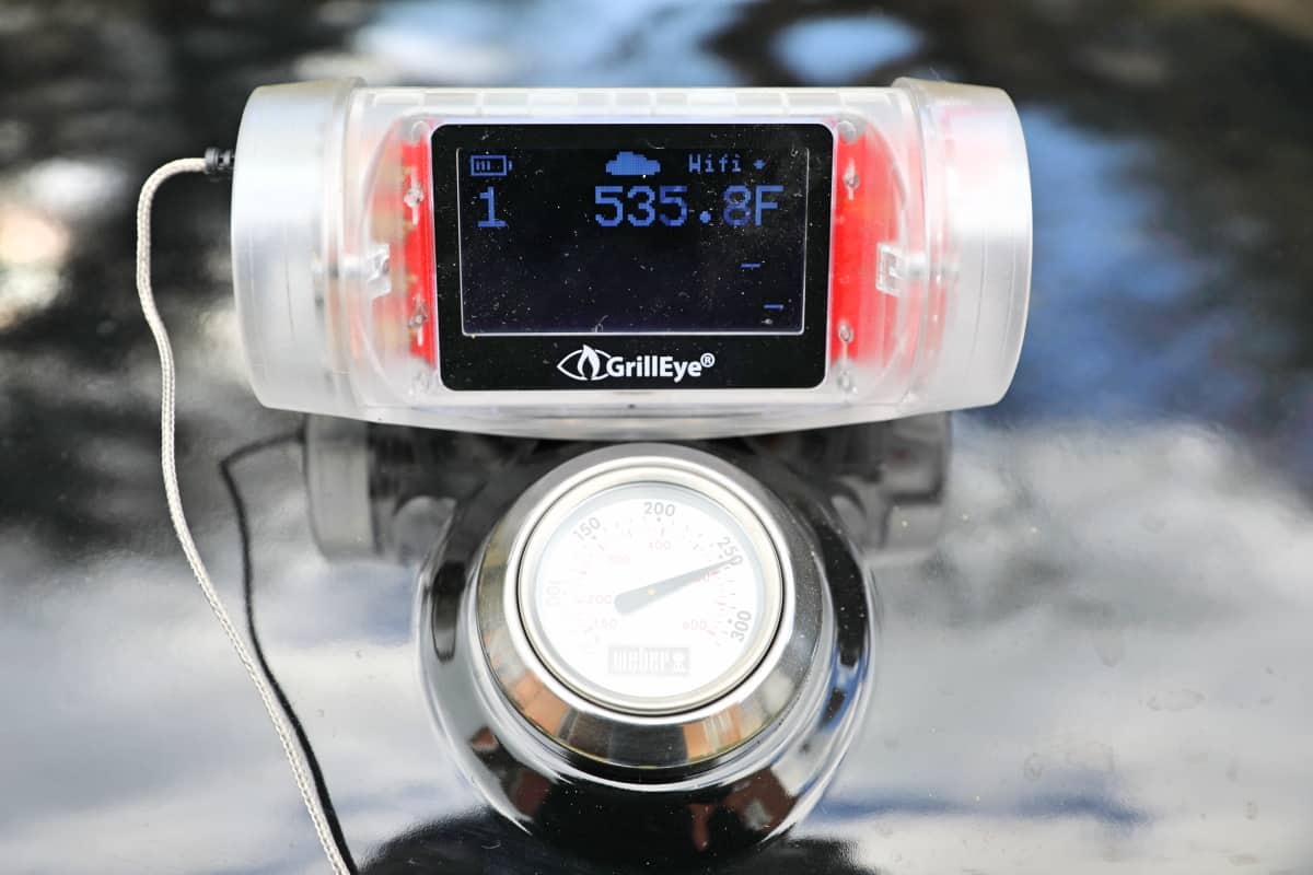 Close up of Weber Traveler lid thermometer and a Grilleye Max Thermometer display