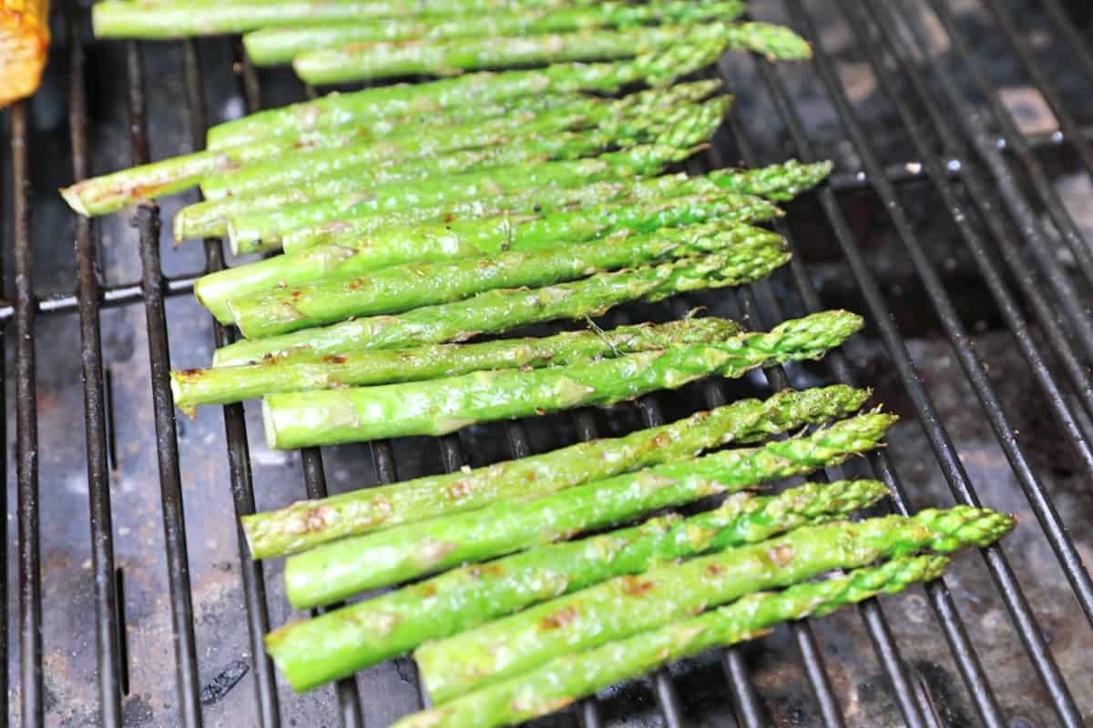 Close up of asparagus grilling in the main chamber of a Camp Chef Woodwind Wi-Fi 36.