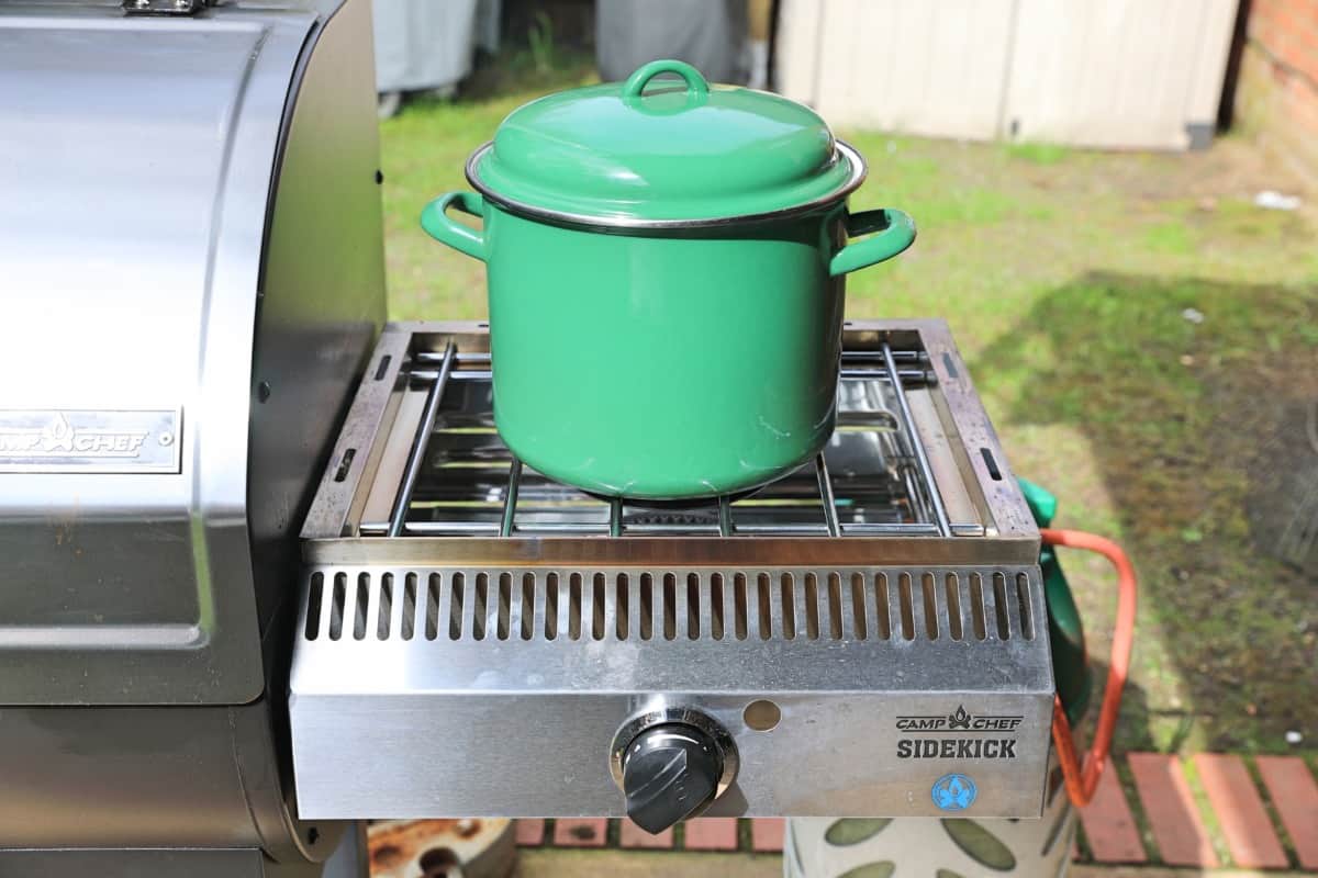 A green ceramic coated pot, boiling away on the Camp Chef Woodwind Sidekick attachm.