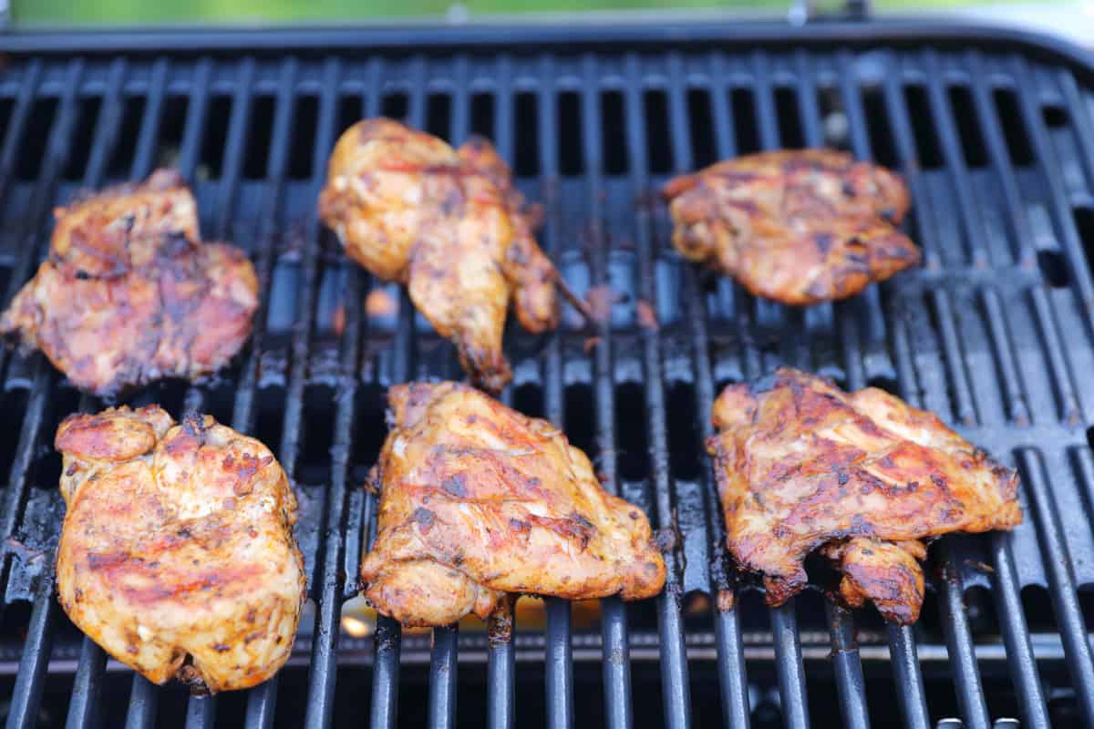 Smoking chicken pieces inside the Weber Traveler grill.