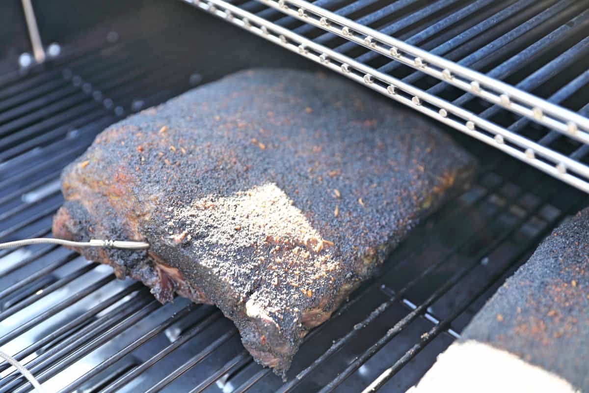 Close up of one rack of beef ribs smoking in a Camp Chef Woodwind pellet smoker.