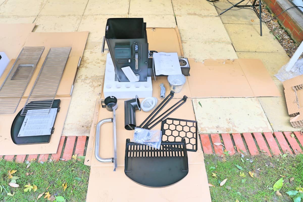Contents of the middle of three boxes that the Camp Chef Woodwind Wi-Fi 36 arrives in, laid out on a patio