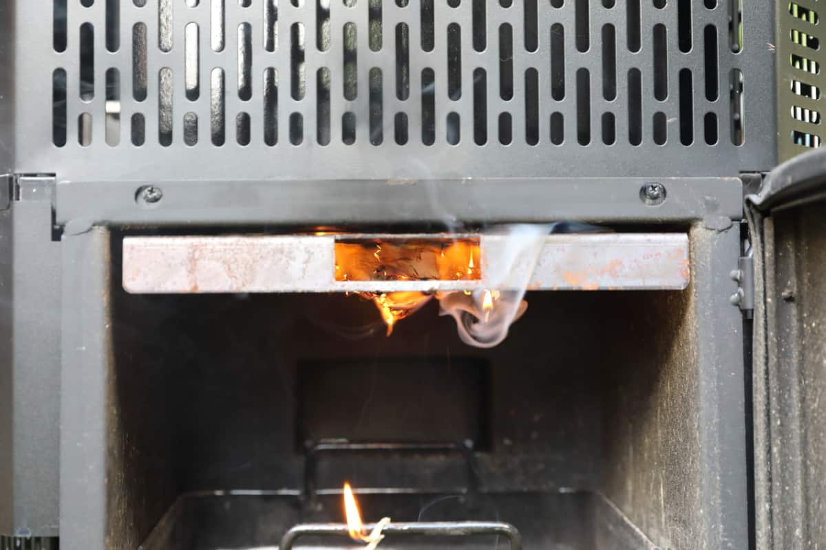A firelighter lit in the charcoal grate of the Masterbuilt gravity series smoker