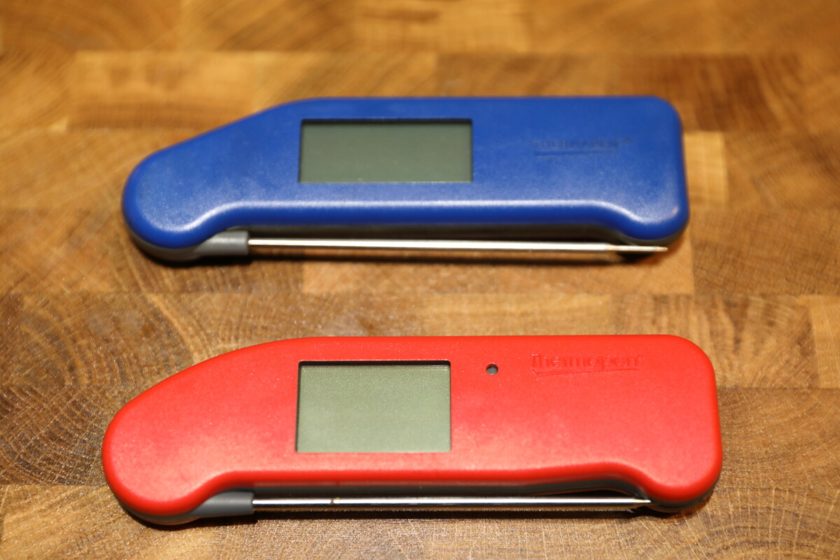 Blue Thermoworks MK4 and a red ONE on a wooden table.
