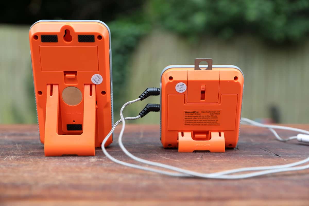 The backs of the ThermoPro TP826 transmitter and receiver, sitting on a wood cutting board.