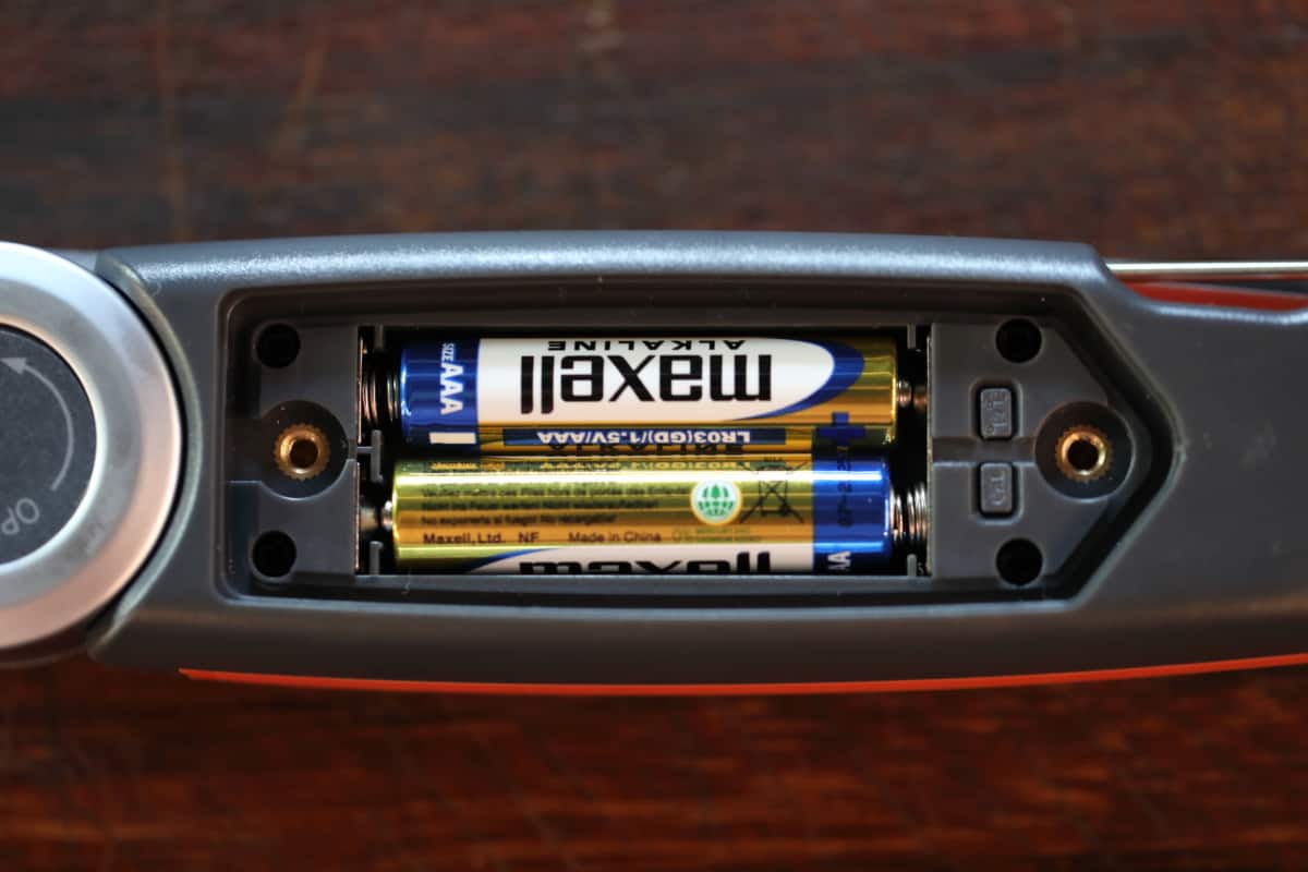 The ChefsTemp FinalTouch X10 with battery cover removed, showing the batteries and two buttons used for settings.