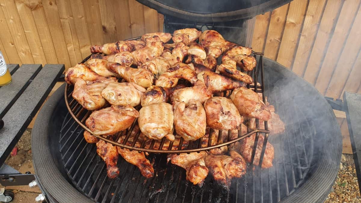 Two tiers of chicken pieces roasting in a KJ Big Joe III.