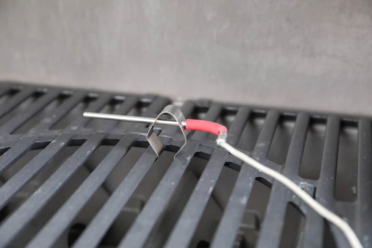 Weber iGrill3 pit probe, in its clip and inserted into a grill grate