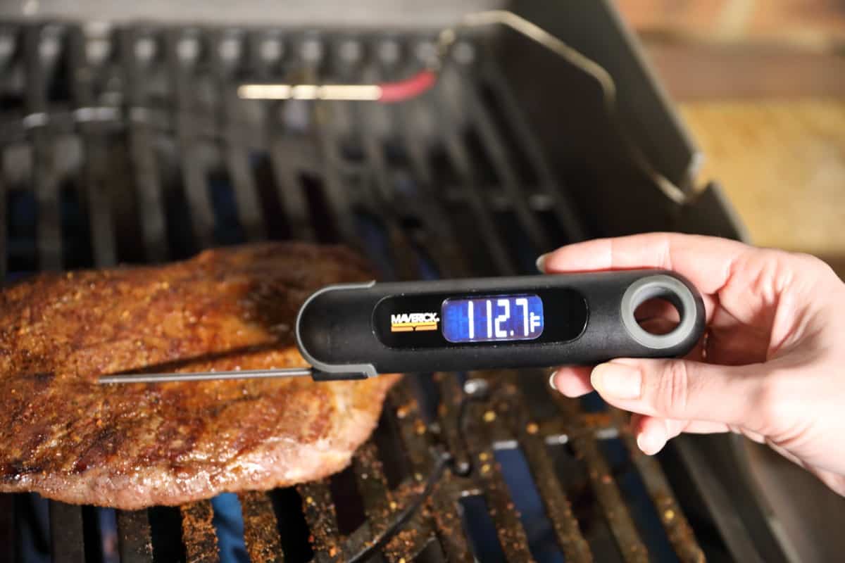 Maverick PT-75 measuring the temperature of a steak on a gr.