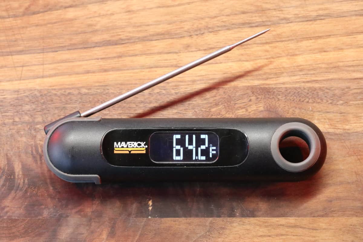 Maverick PT-75 thermometer on a wooden cutting board, with 64..2 degrees Fahrenheit on the display