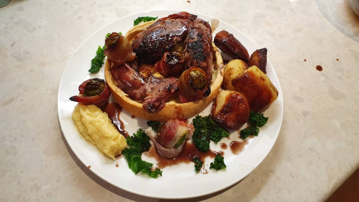 A roasted partridge tart, with some purees and greens on a plate.