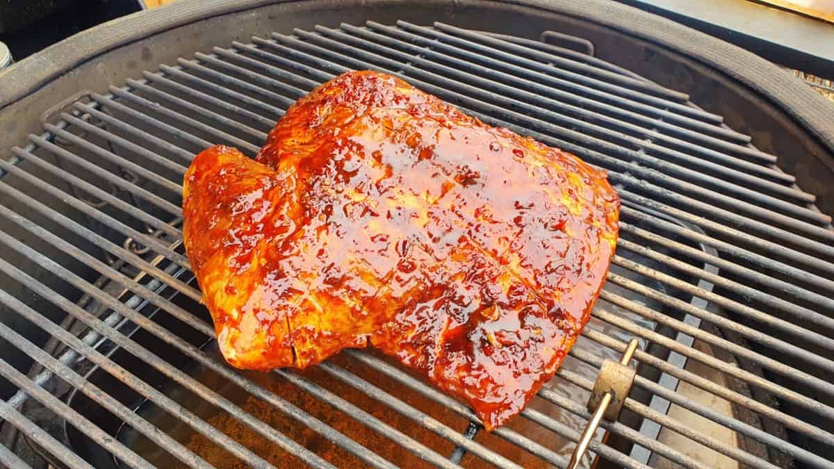 Marinated lamb shoulder smoking in a KJ Big Joe III.