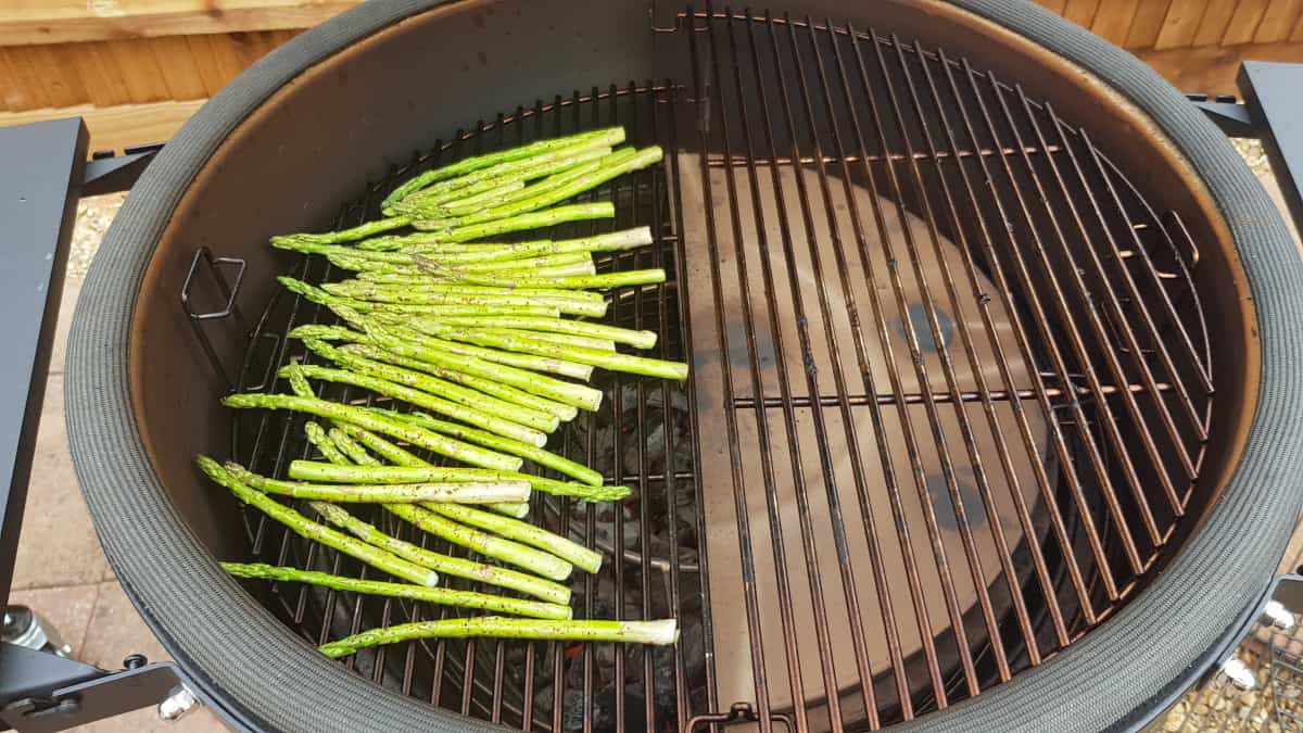 Asparagus being grilled inside a Kamado Joe Big Joe III.