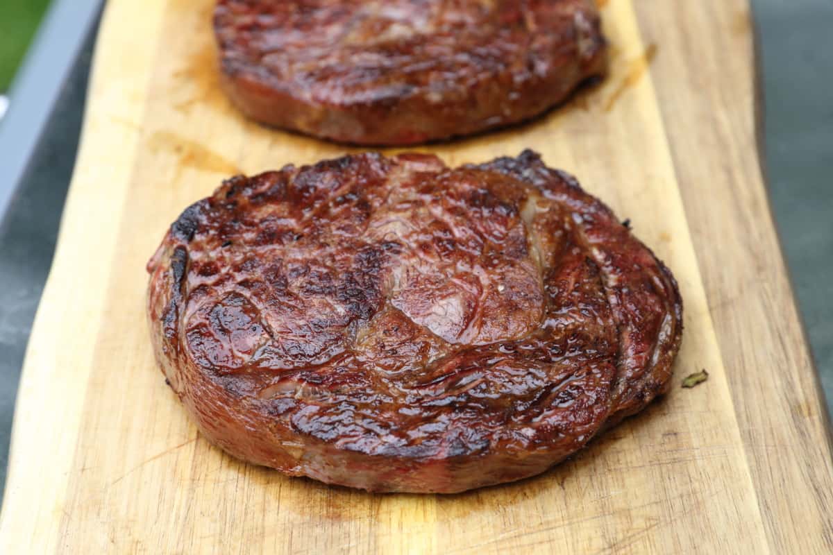 Two seared steaks on a cutting board