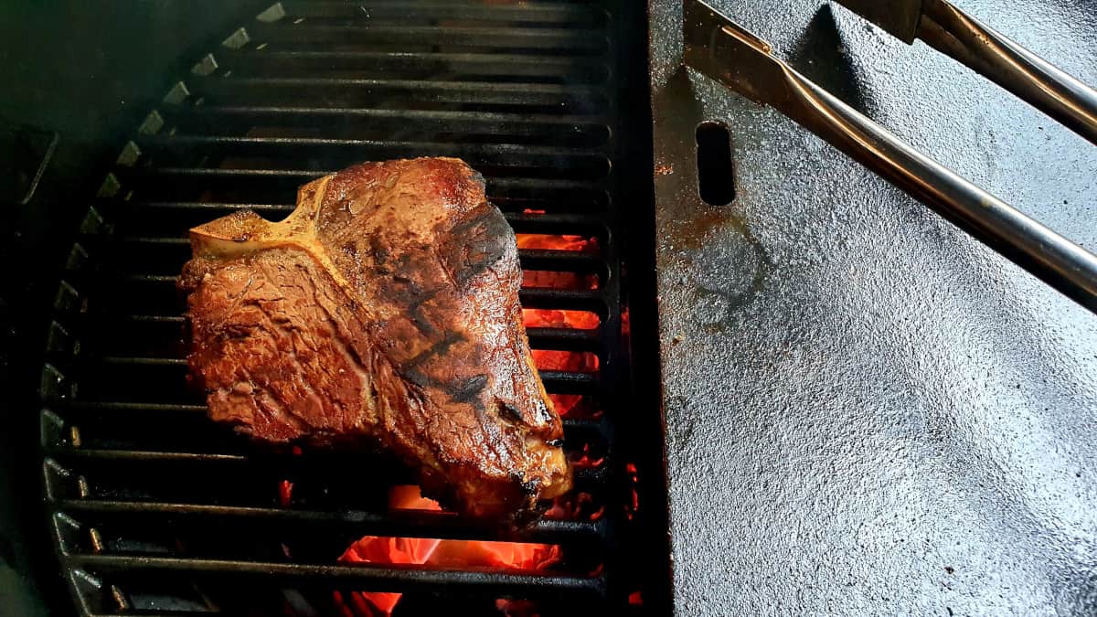 A T-Bone steak being grilled in a Kamado Joe Big Joe III.