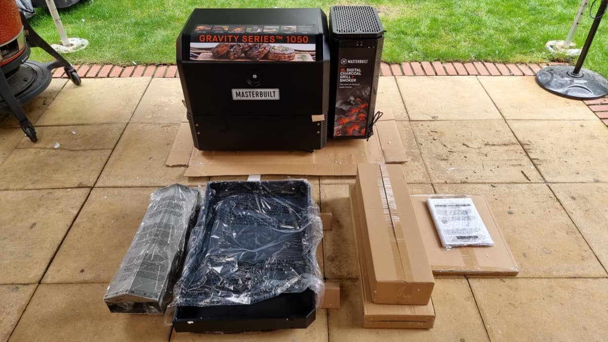 Masterbuilt gravity series box opened, with some items spread out around a patio