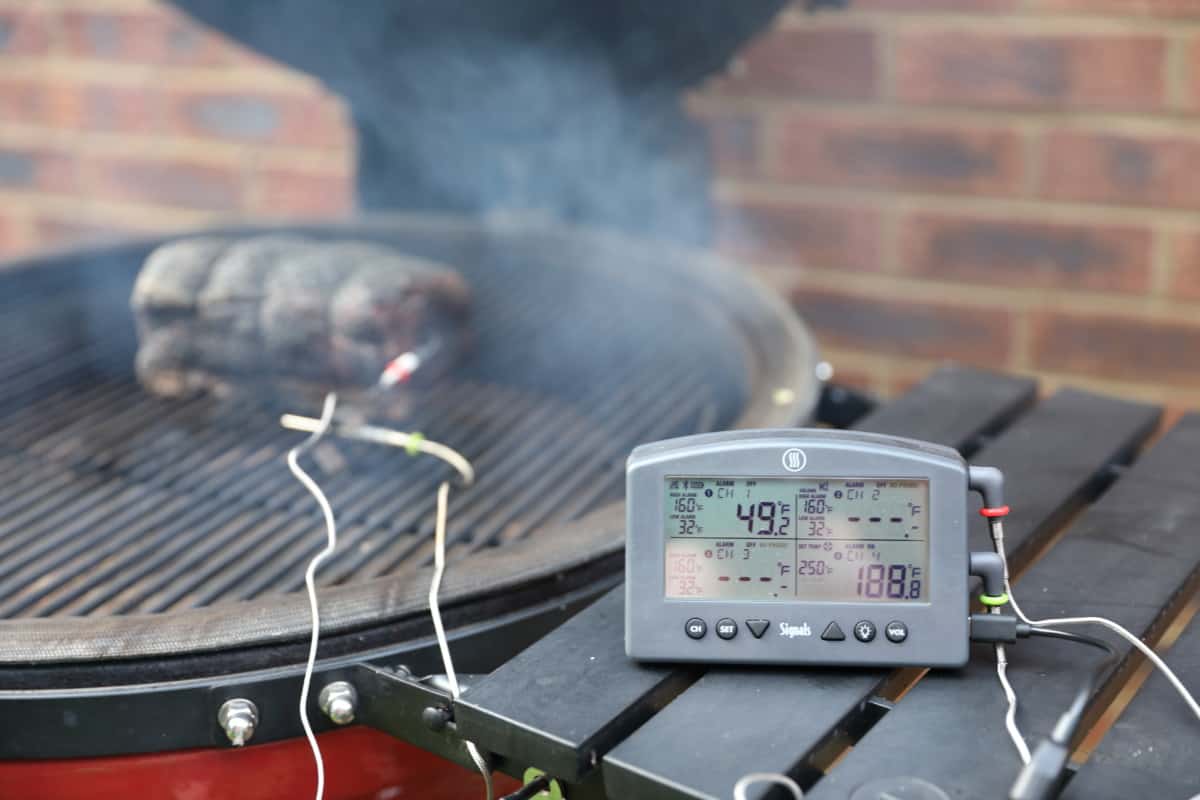 Thermoworks Signals thermometer on the right side table of a Kamado Joe smoker.