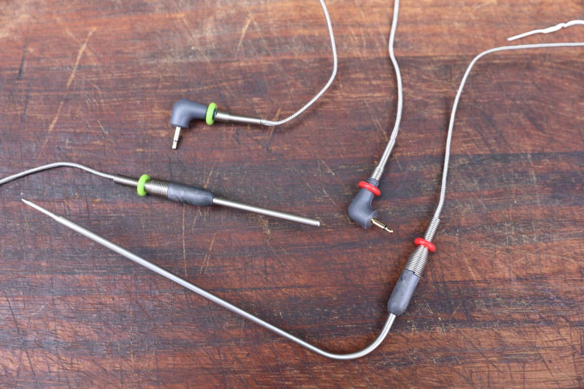 Thermoworks Signals food and ambient pit probe, with their plug ends, on a wooden table.