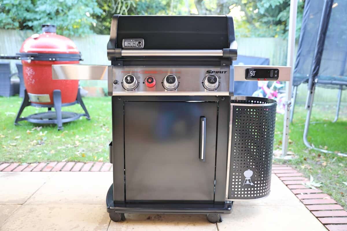 Weber Spirit EPX-325S on a patio, with a red Kamado Joe in the background.