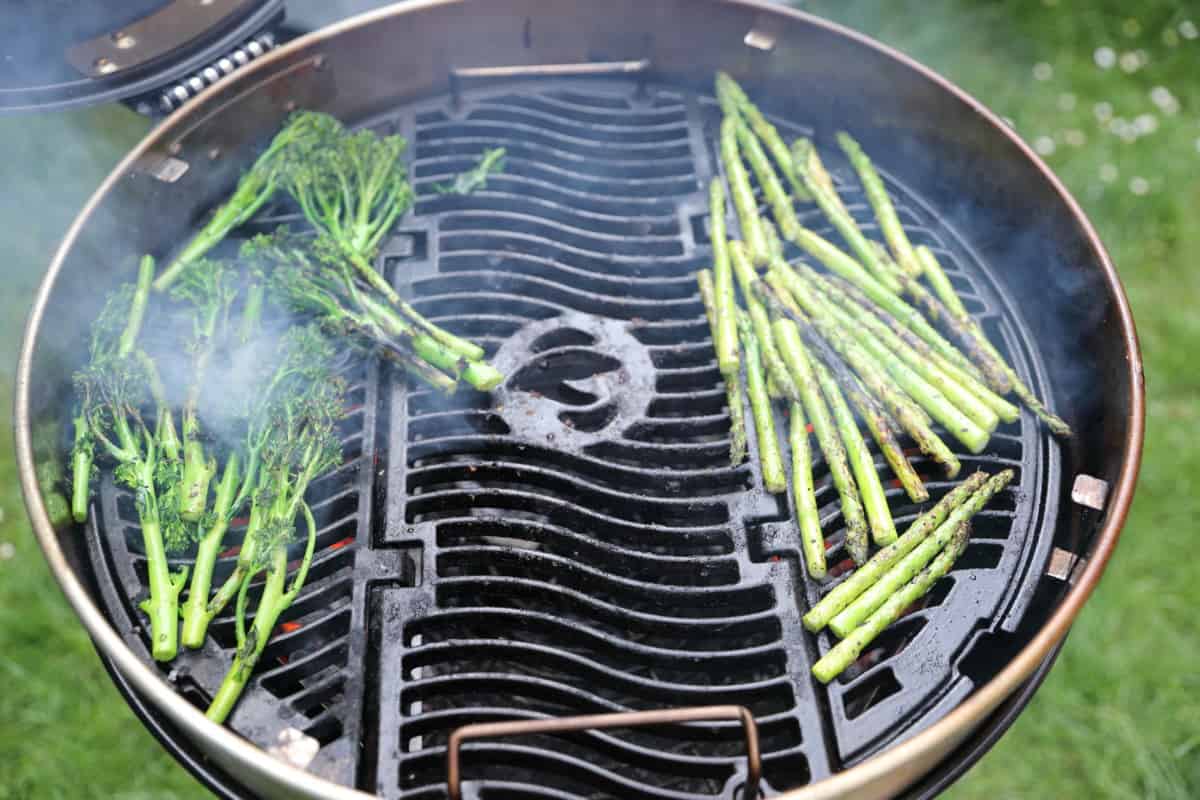 broccoli and asparagus being grilled on a charcoal grill.