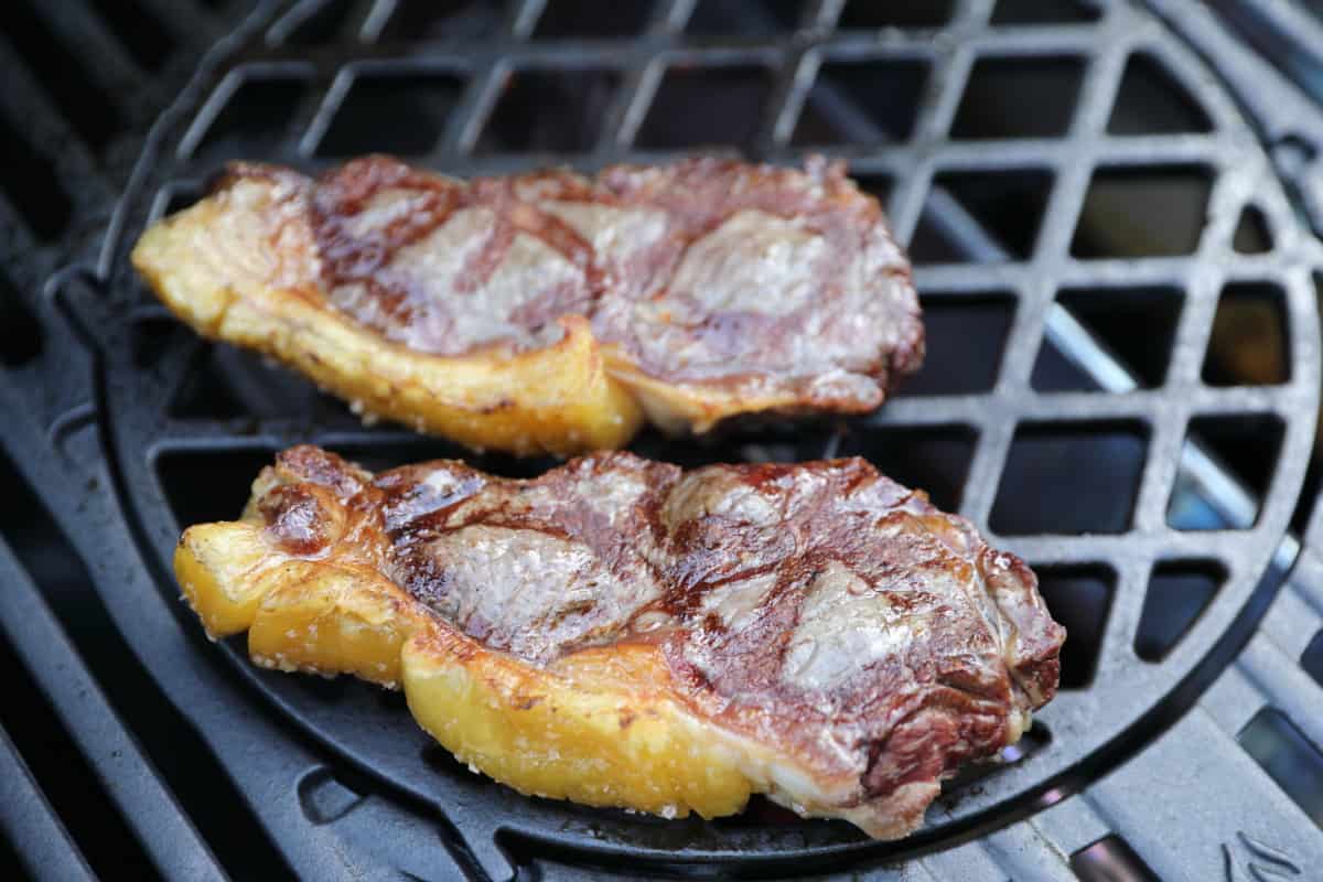 Two sirloin steaks on a Weber GBS grate, showing grill marks from the diamond patterned gra.