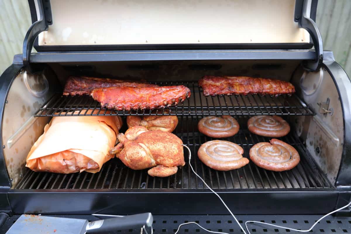 Close up of the Z Grills 11002B multitasker pellet grill filled with different meats being smo.