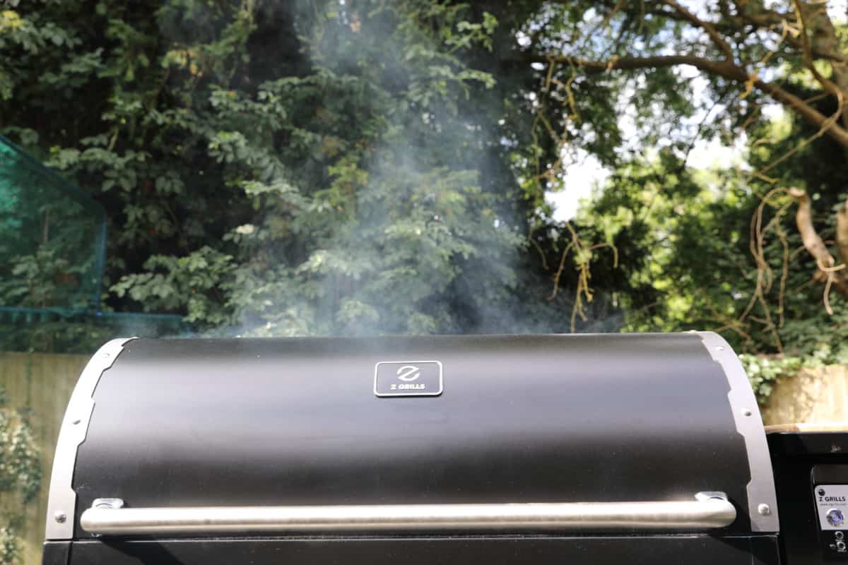 z grills 11002b lid with smoke seeping up into the sky