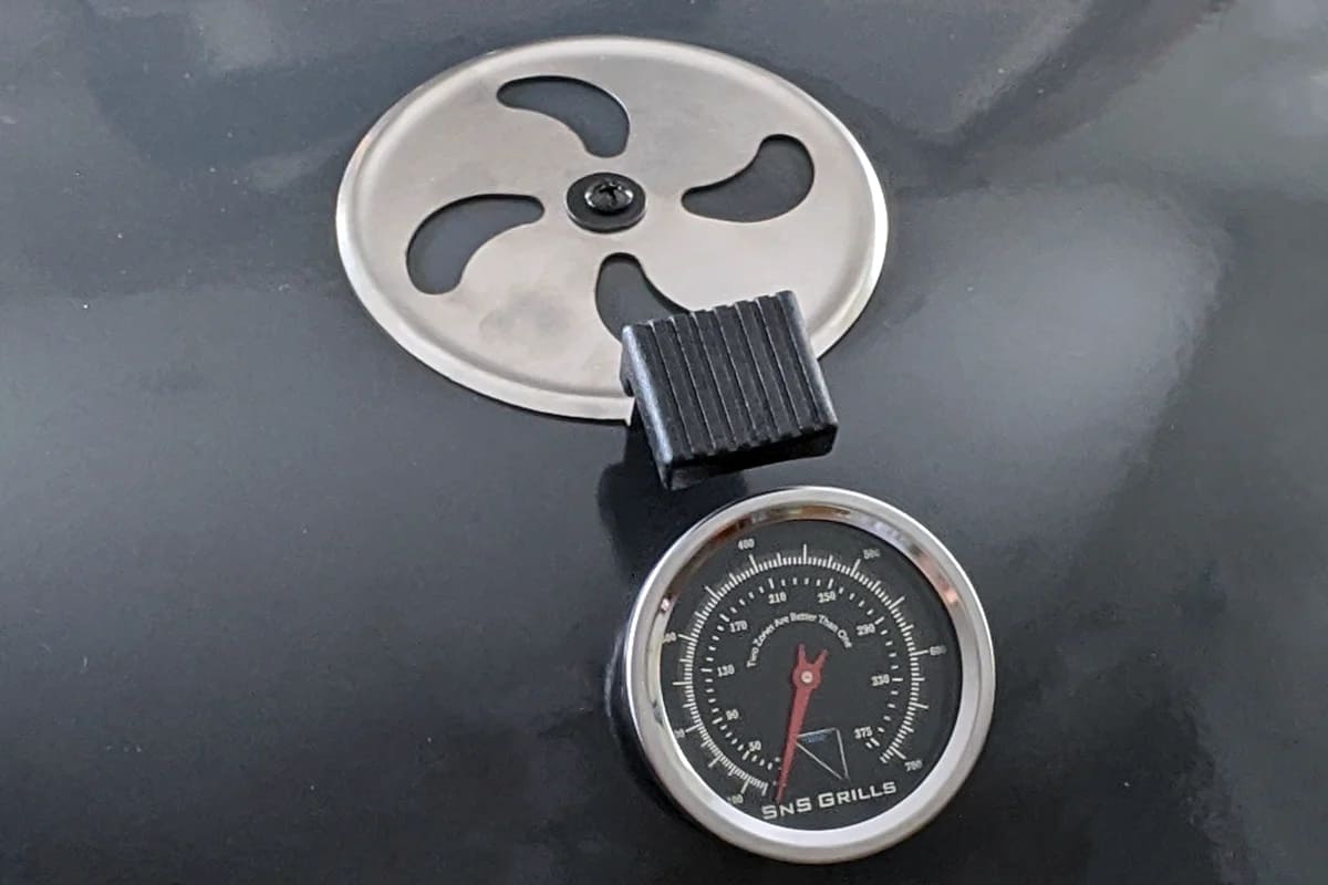 Close up of the Slow N Sear Kettle Grill thermometer and vent