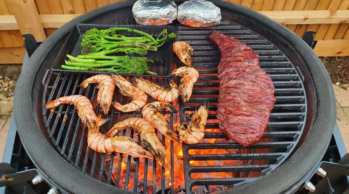 Bavette steak, crevettes, and broccoli being cooked on a kamado grill and smoker.