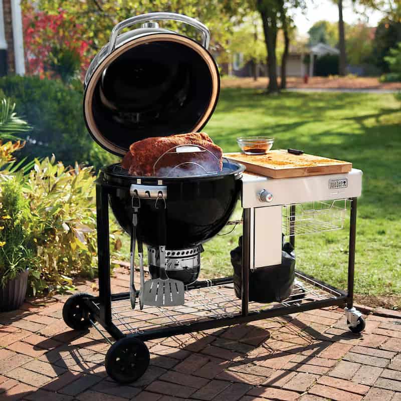 Weber Summit S6 in use, with ribs on the grill, and a cutting board on the side table