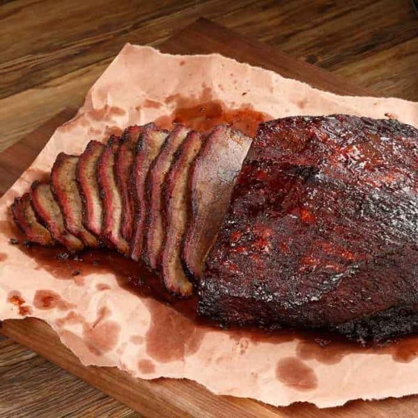 A Snake River Farms brisket, smoked, and sitting on some pink butcher paper.