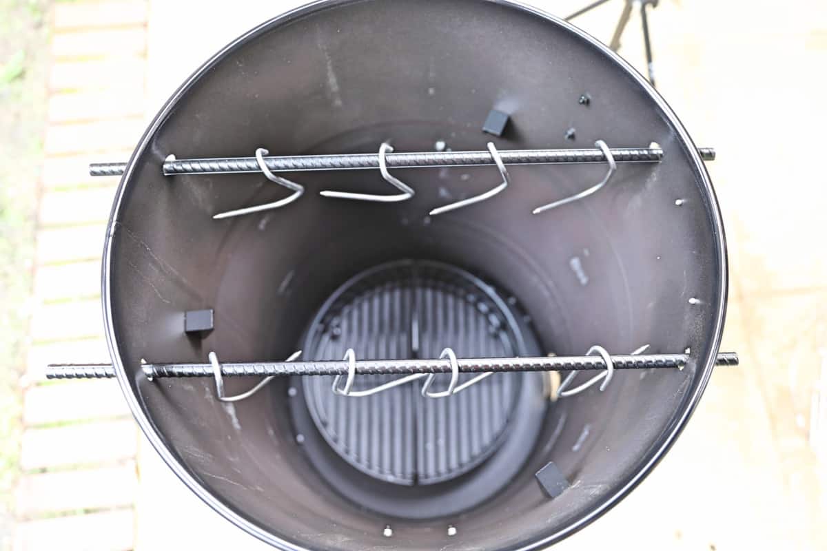 Looking down inside the Pit Barrel Cooker to see two rows of meat hooks.