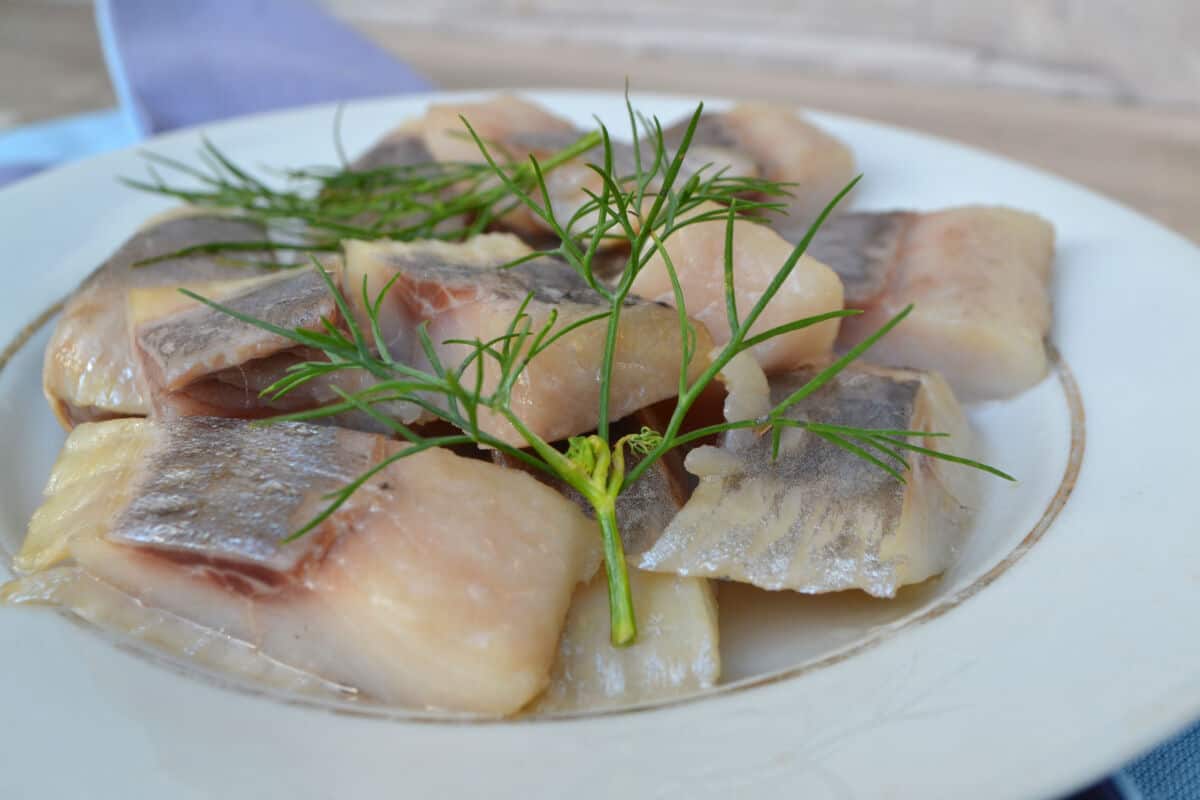 Alewife steaks in a shallow dish, with what looks like dill placed on .