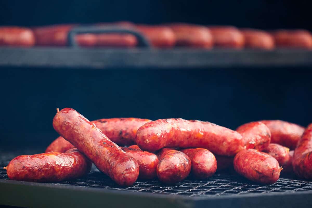 A small pile of grilled andouille sausages on a bbq grill gr.