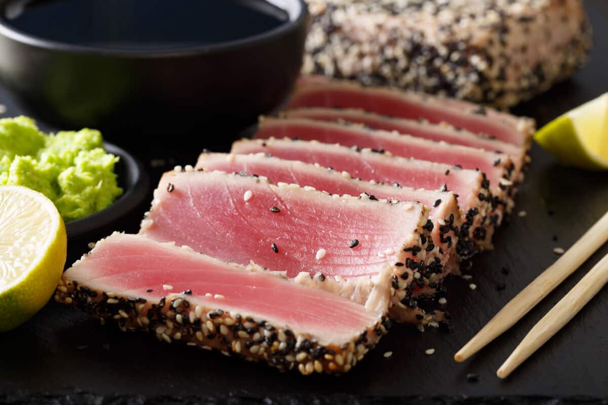 Seared ahi tuna slices with sushi style accompanime.