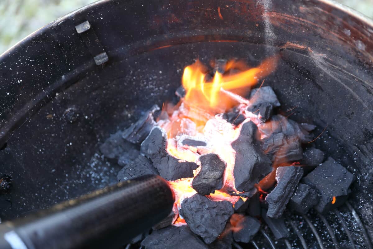 A lit charcoal fire being blown by a Looft Air Lighter X.