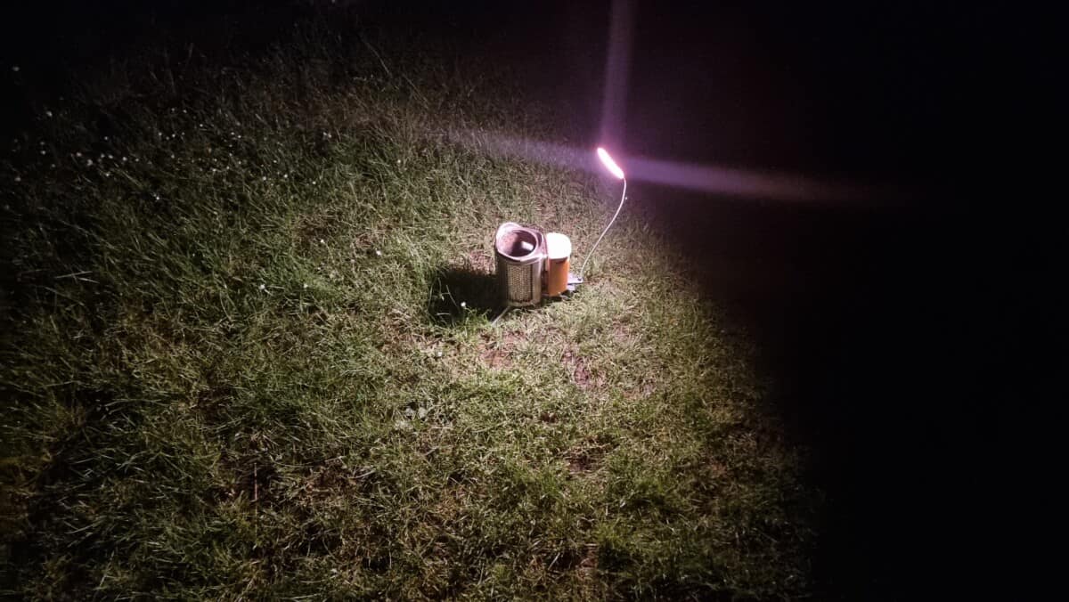 Biolite CampStove light connected and illuminating the grassy ground.