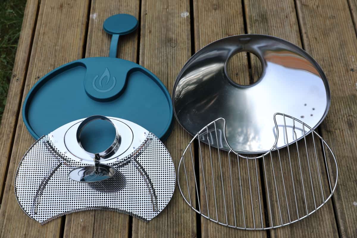Biolite CampStove grill and cover plate laid out on a metal table.