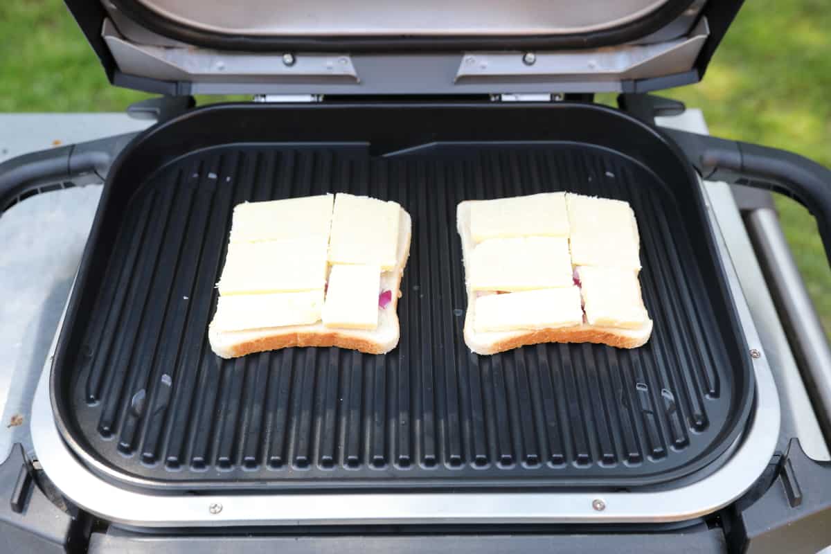 Two pieces of uncooked cheese on toast on the Ninja Woodfire grate.