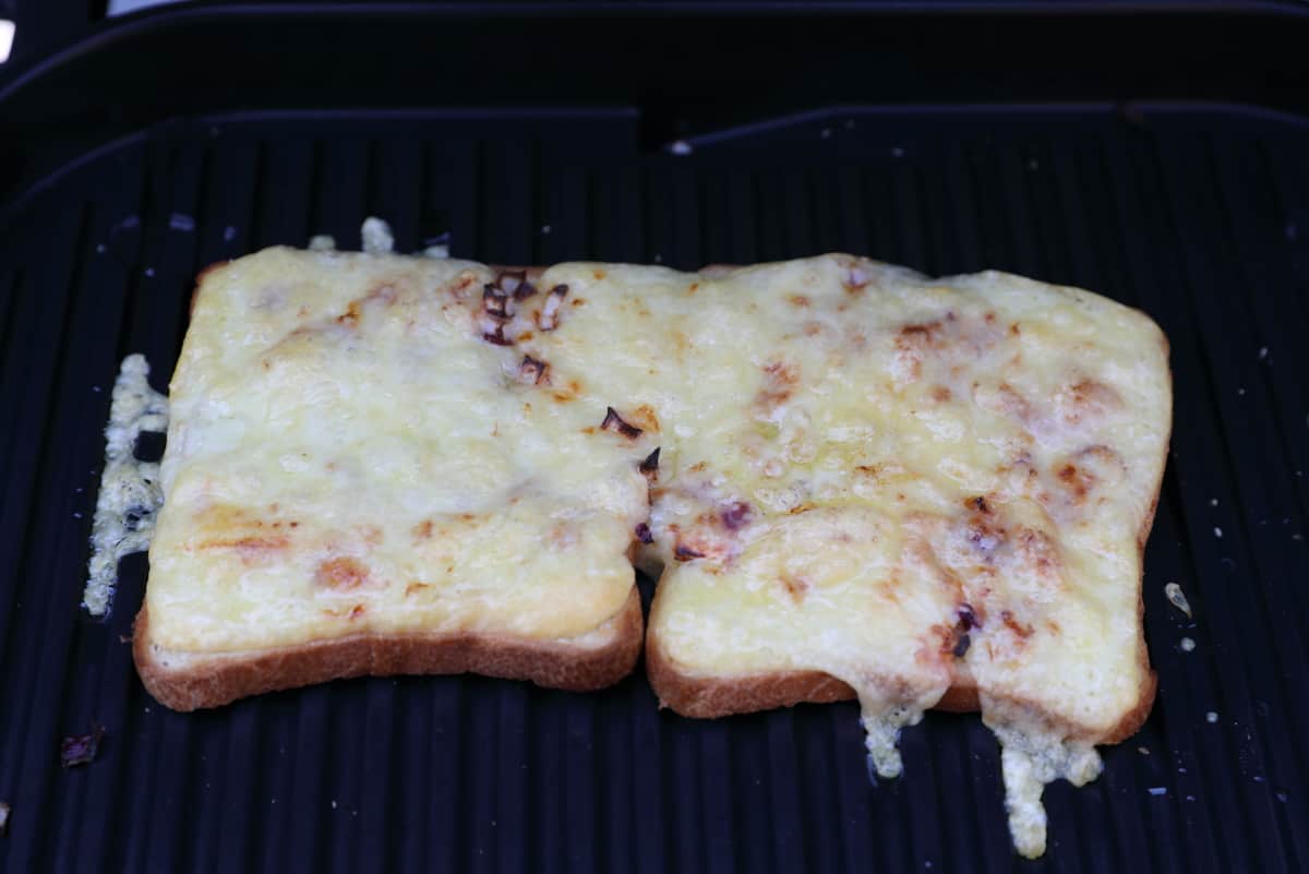 Two slices of chees on toast on the Ninja Woodfire grate.