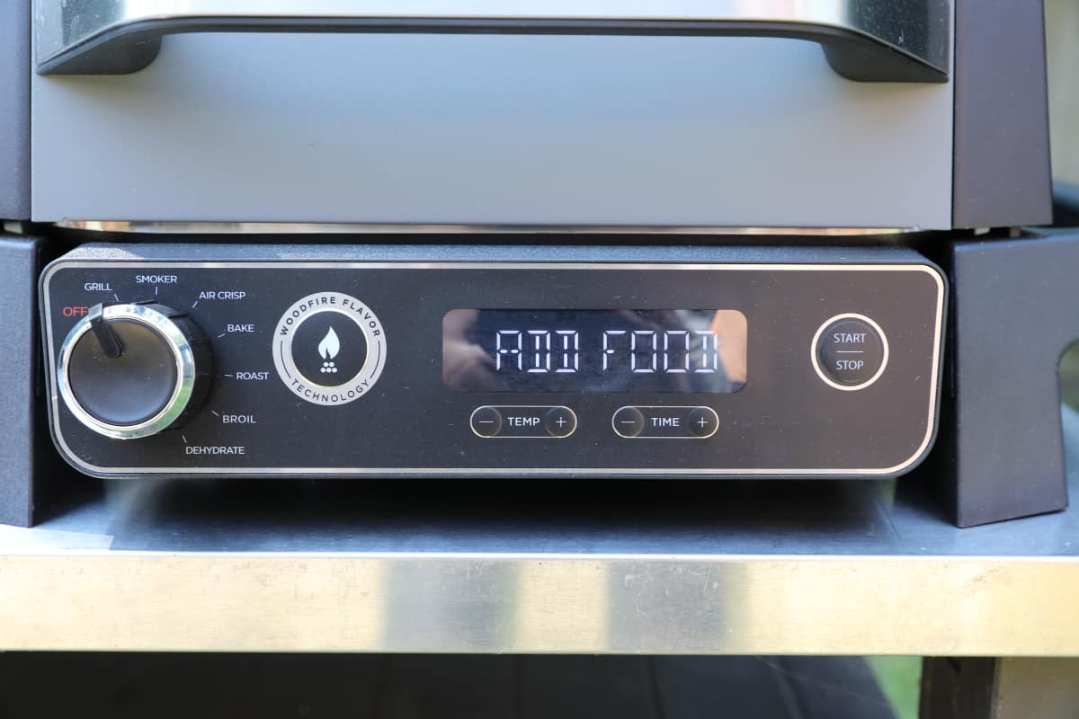 Close up of the control panel of the Ninja Woodfire showing 'add food.'