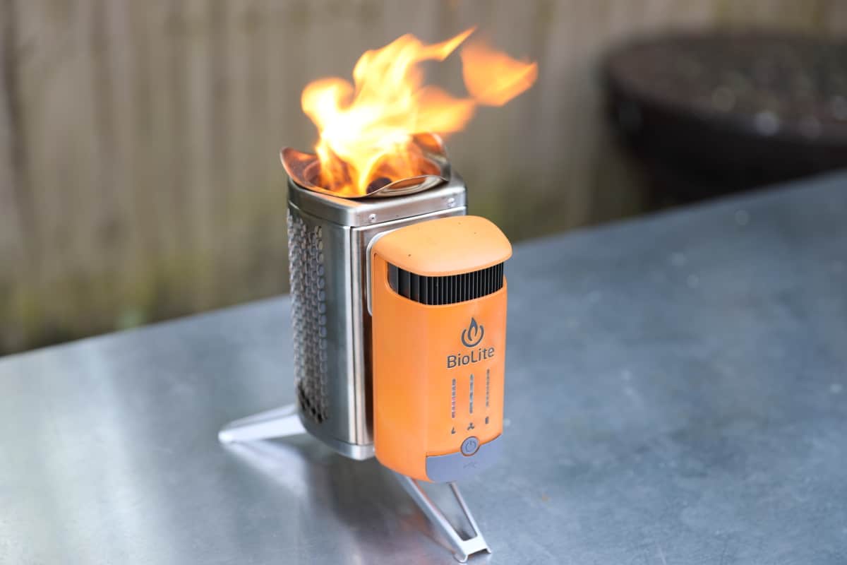 Biolite Campstove 2+ lit and standing on a metal table.