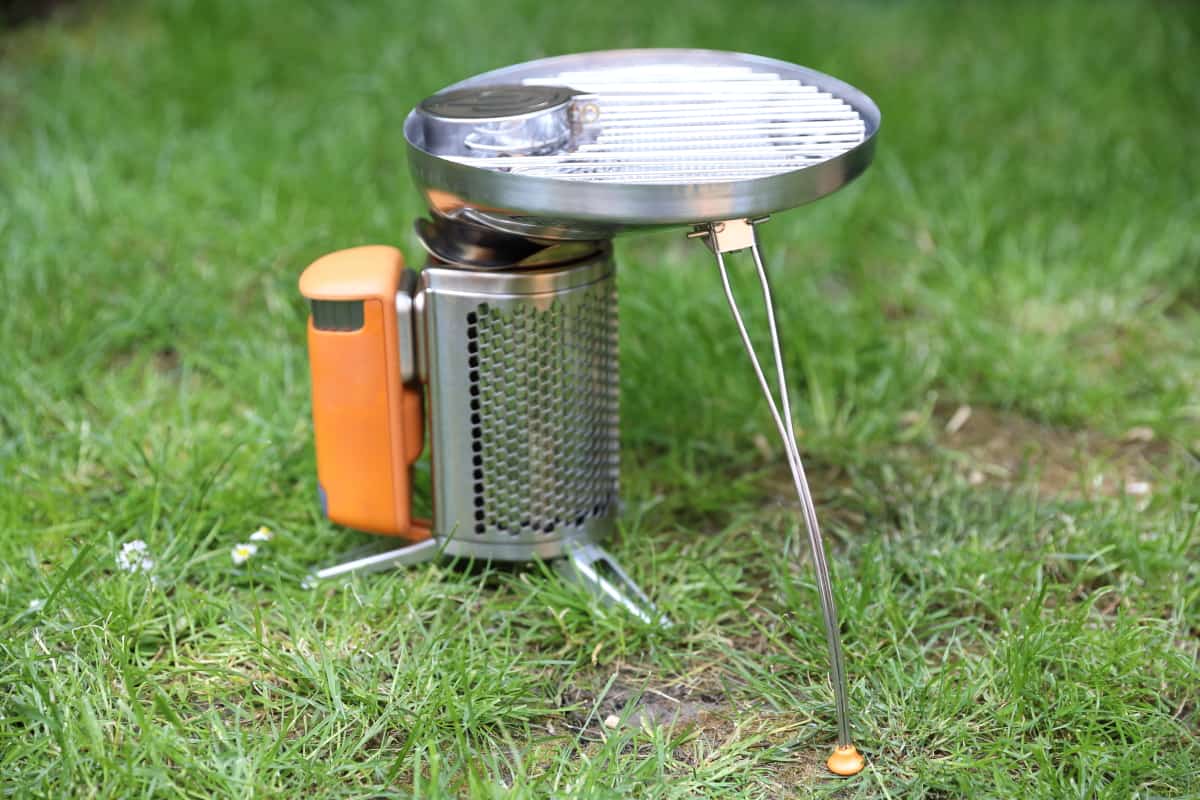 Biolite Campstove 2+ set up with the grill accessory attached, sitting on grass.