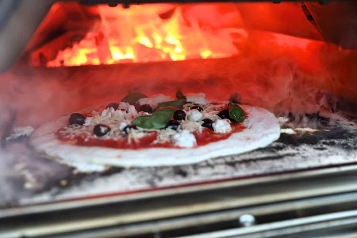 A pizza cooking inside the Ooni Karu 16.