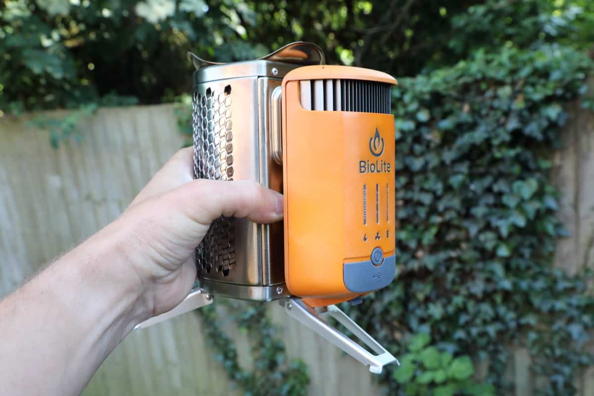 Biolite CampStove being held up by a mans hand, showing how small it is.