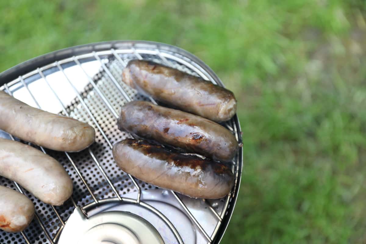 soot covered sausages on the Biolite CampStove grill grate.